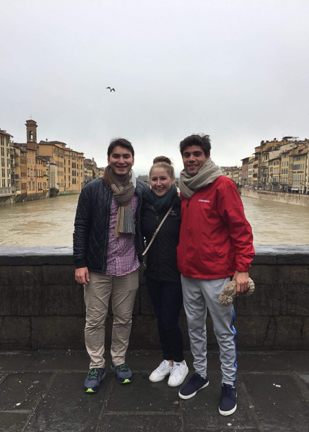 Photo of Charlotte and two other men with a river and city in the background