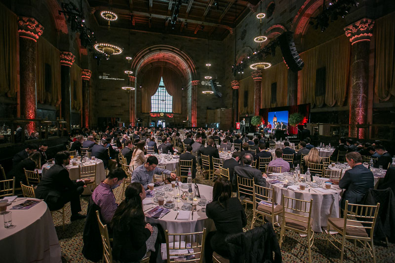 Photo of a packed ballroom with tables