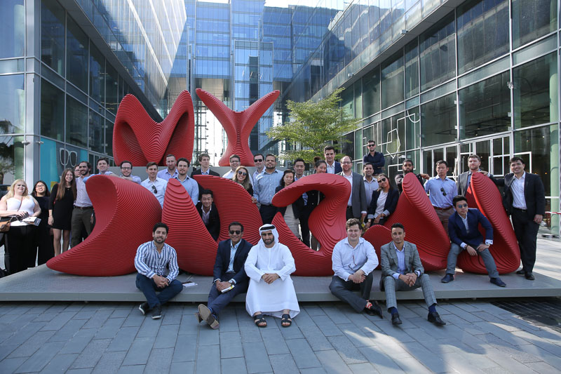 Photo of people surrounding a large statue in an outdoor plaza