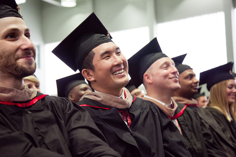 Photo of seated, smiling graduates