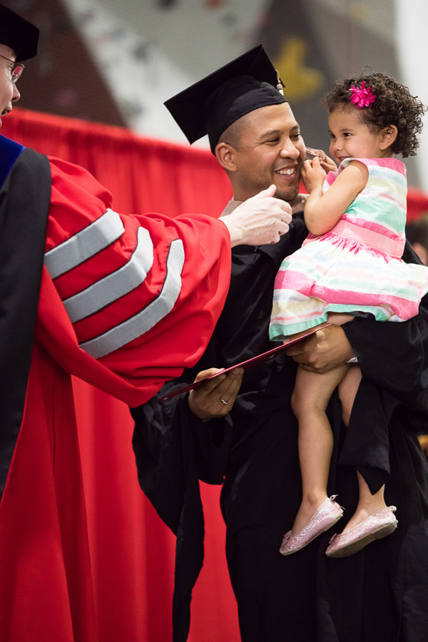 Photo of a graduate with his young daughter