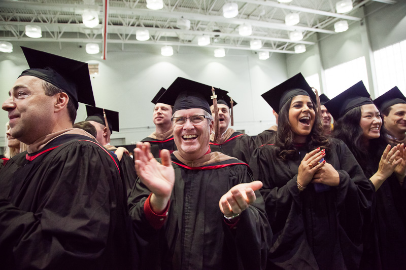 Photo of celebrating, clapping graduates