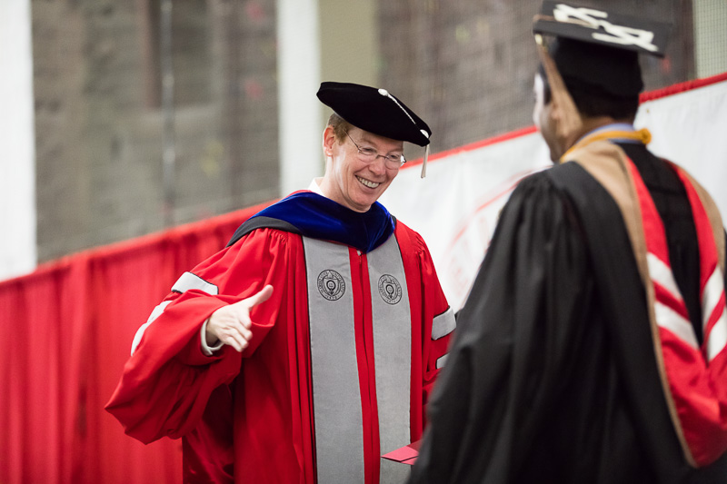 Photo of Mark Nelson shaking a graduate's hand