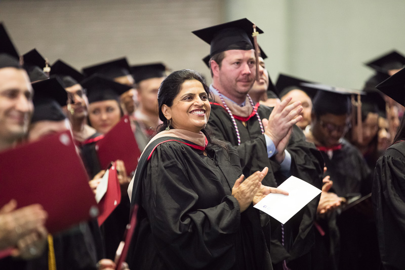 Photo of clapping, standing graduates