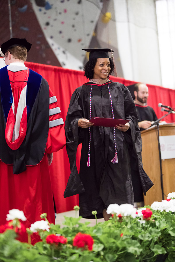 Photo of a graduate walking across the stage with her degree