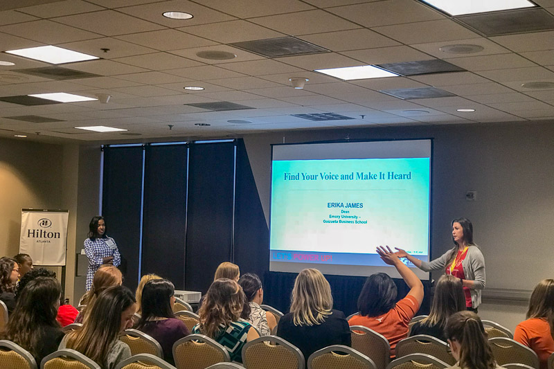 Photo of two women standing at the front of the room presenting to an audience