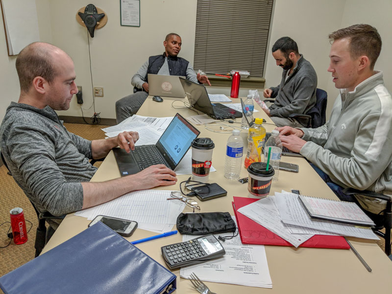 Photo of a team working at laptops around a table