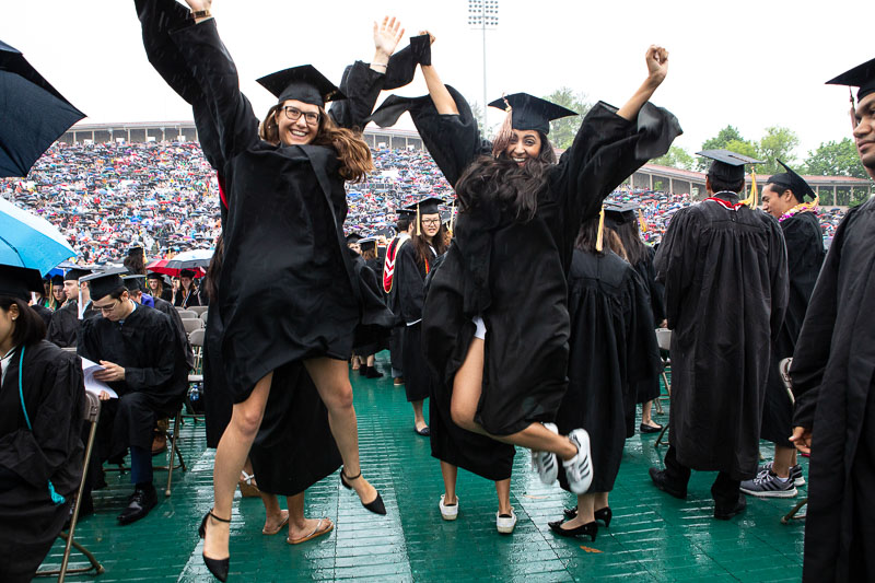 Photo of two graduates jumping in the air