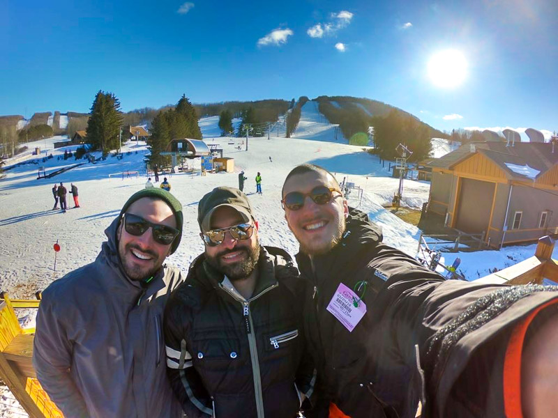 Photo of three men at a ski resort