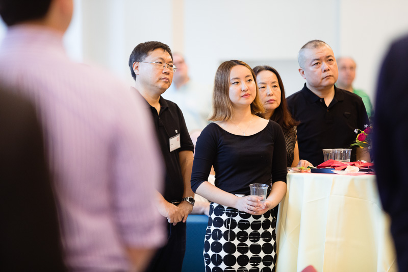 Photo of people standing and listening