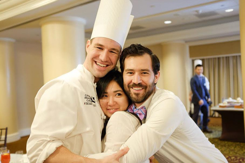 Photo of three students in chef's attire hugging