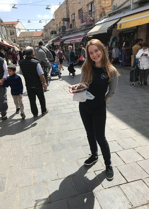 Photo of Rachel holding a plate of food in a marketplace