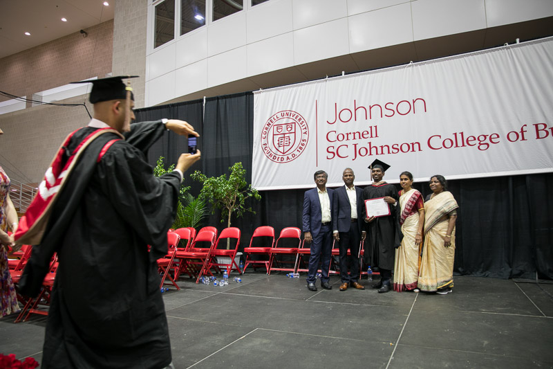 Photo of a graduate and his family under the Johnson banner