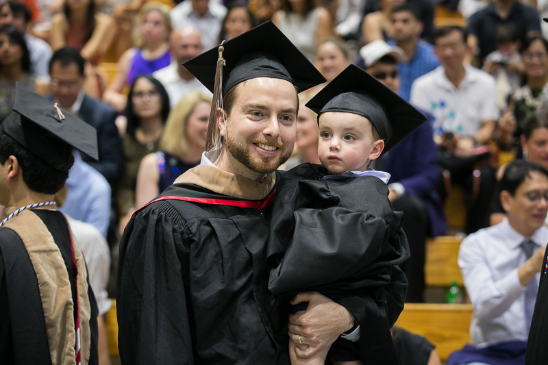 Photo of a graduate holding a child