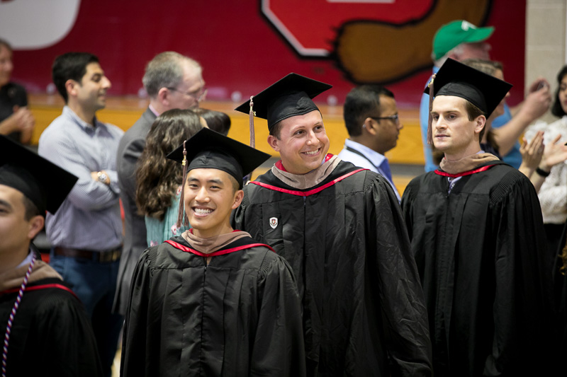 Photo of walking, smiling graduates