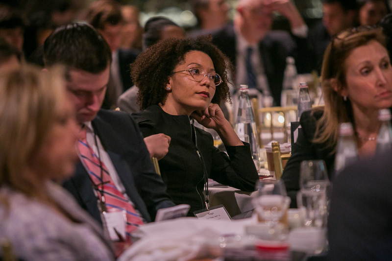 Photo of a woman seating at a table in the audience