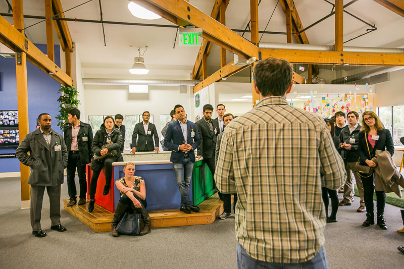 Photo of the group listing to a speaker in an open office space