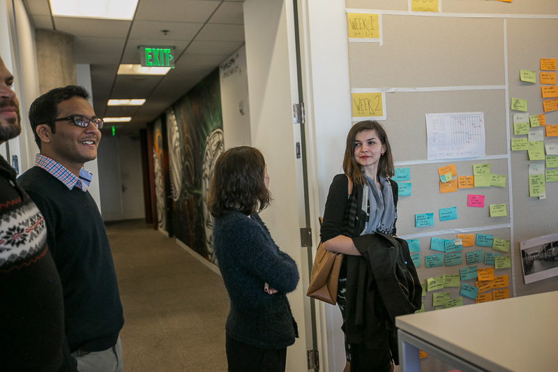 Photo of two women looking at a wall of post-it notes