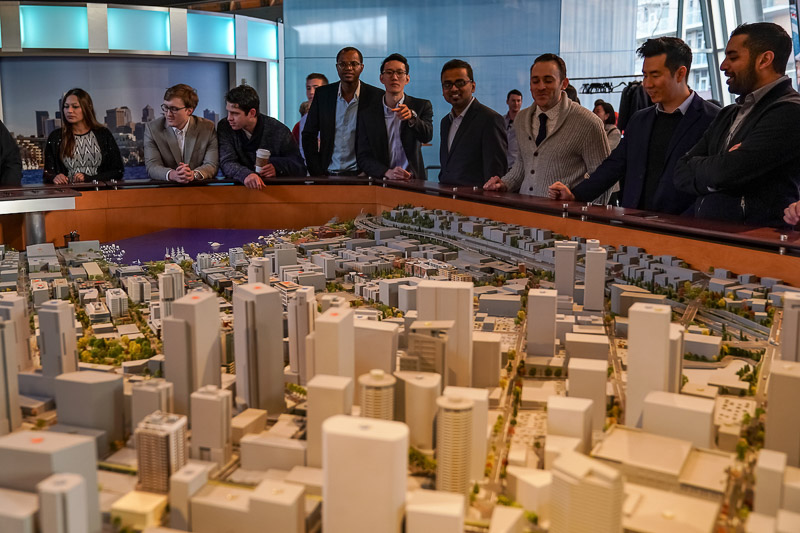 Photo of a close up of a scale model of a large city; students looking in the background