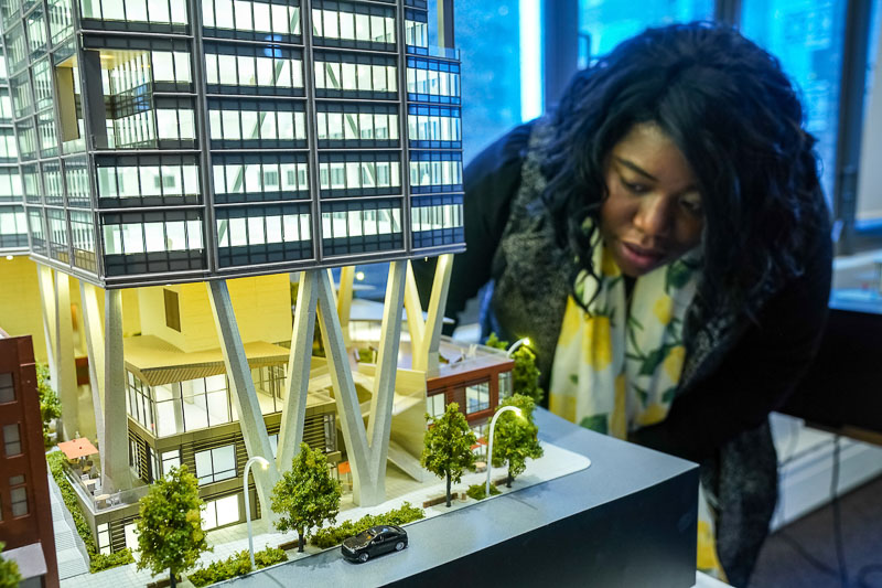 Photo of a woman looking at a model of a building