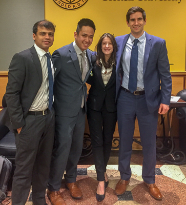 Photo of four teammates standing in the Sage Hall lobby