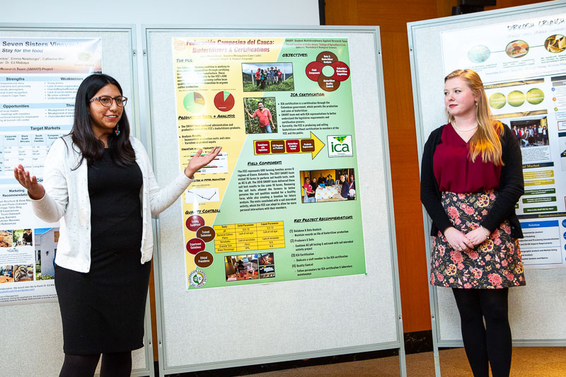 Photo of two females presenting with posters