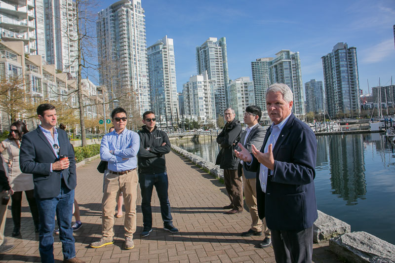 Photo of a group at the side of a river with the city in the background