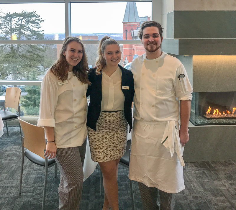 Photo of three students, Gianna and Andrew are wearing chefs attire