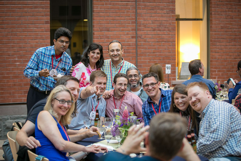 Photo of a group sitting around a table posing for someone taking a picture