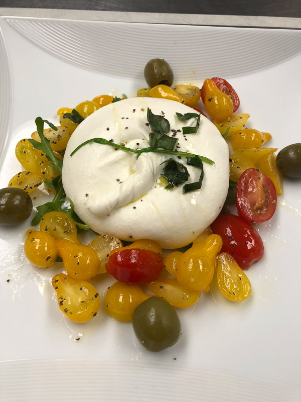 Photo of a plate of food featuring colored tomatoes