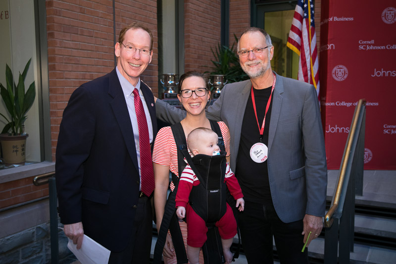 Photo of Dean Nelson, Bob Frank, and a women holding a baby