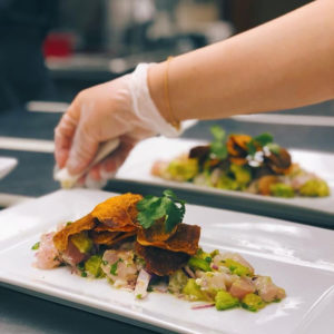 Photo of a student's hand plating a meal