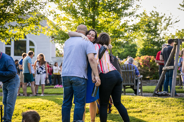 Photo of three people hugging outdoors