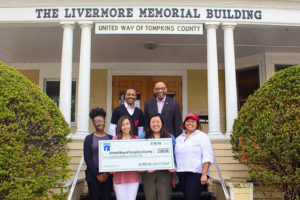 Photo of a group of students holding a large check outside United Way