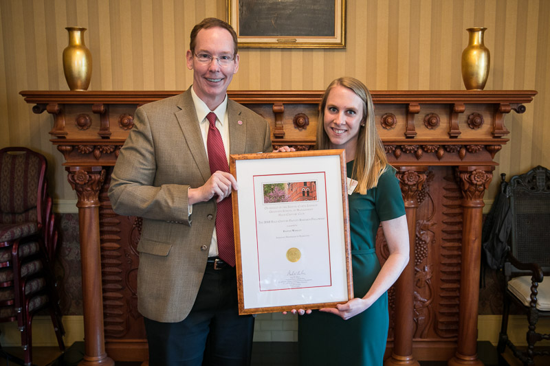 Photo of Dean Nelson and Prof. Woolley holding a framed award in Sage Hall