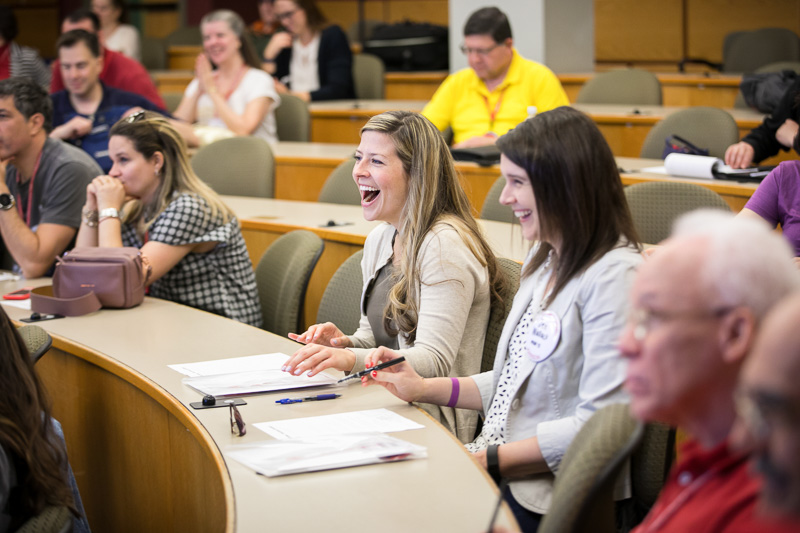 Photo of a women laughing in the audience of Risa's presentation