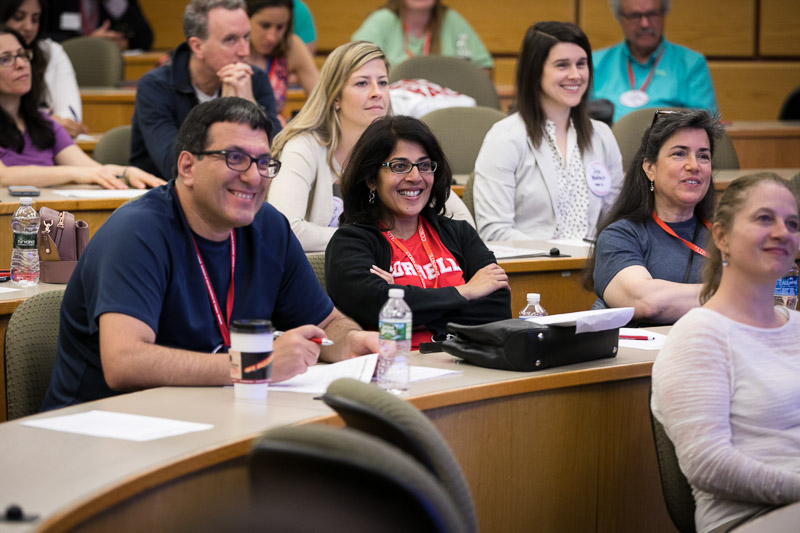 Photo of attendees smiling in the audience of Risa's presentation