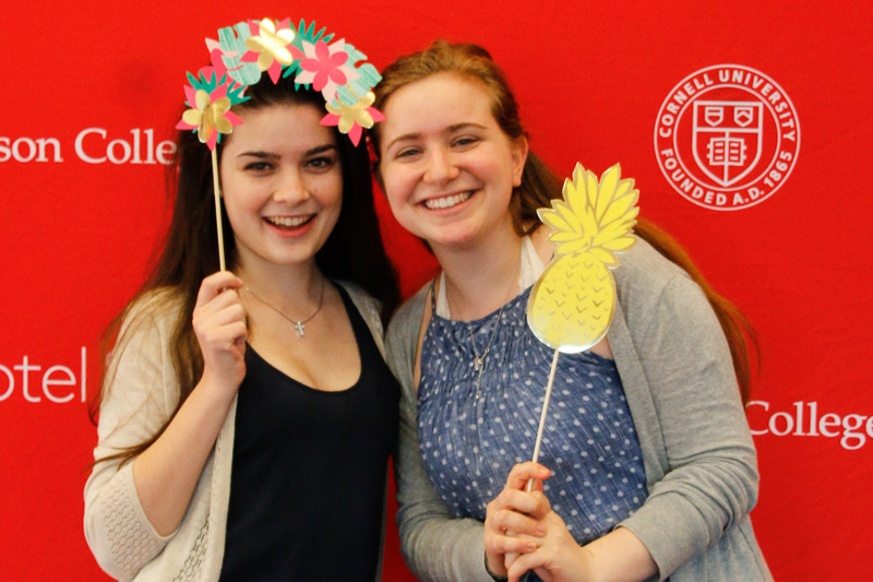 Photo of two girls holding cardboard cutouts of flowers and a pineapple