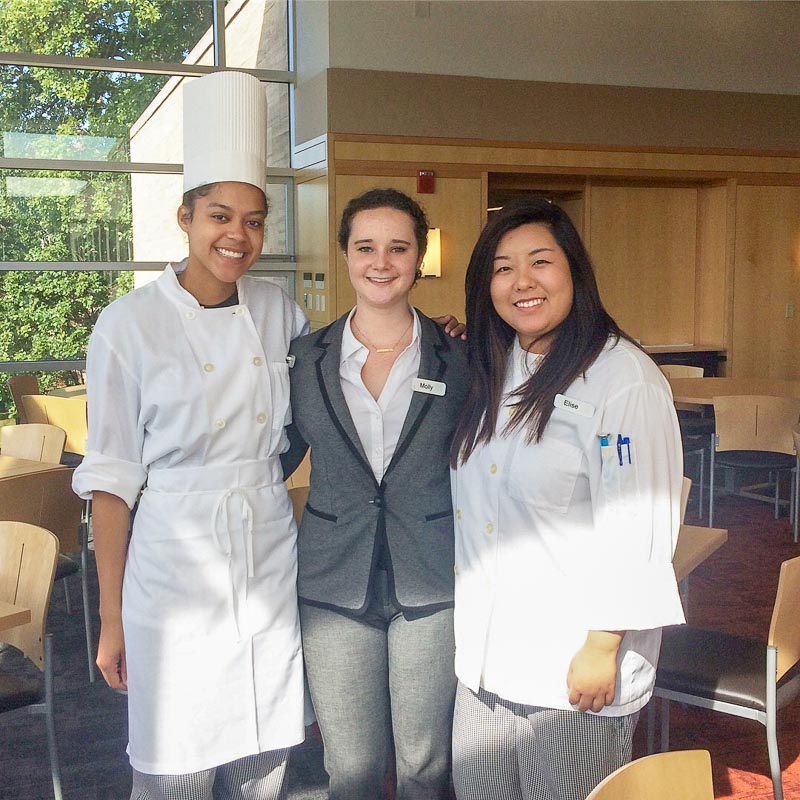 Photo of three students; Alana and Elise are wearing chefs attire