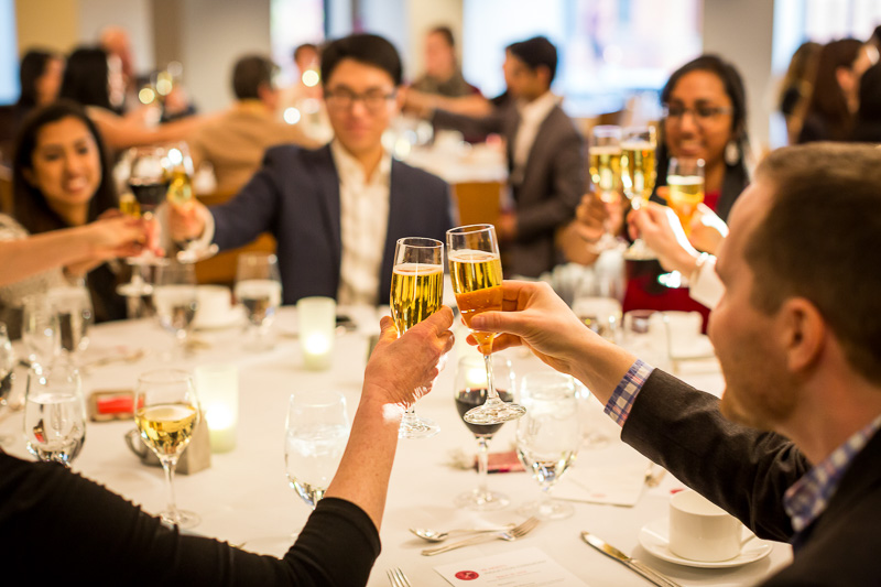 Photo of people around a table raising glasses