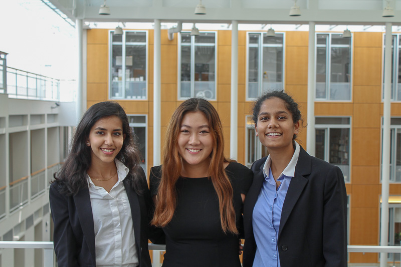 Photo of three students in professional dress posing for a picture