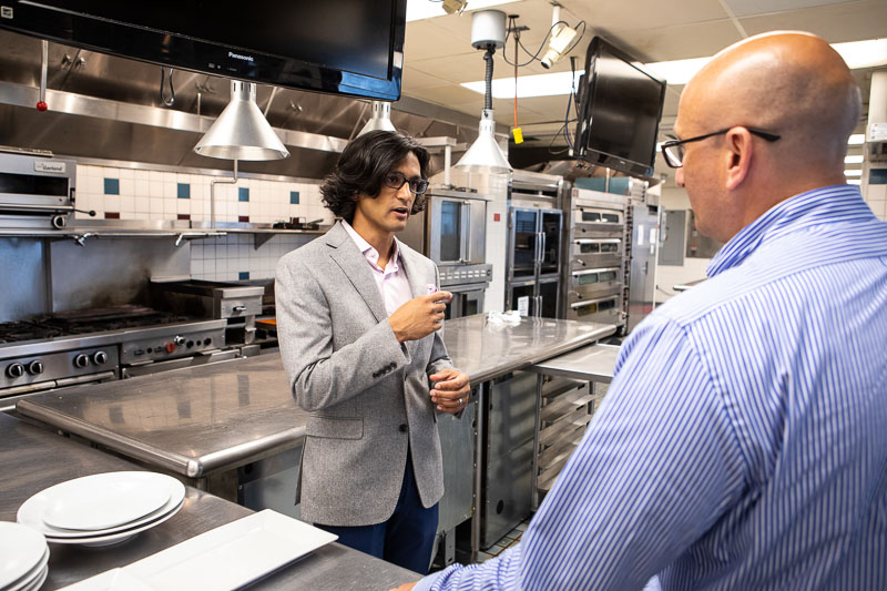 Photo of Aaron speaking in an industrial kitchen