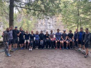 Photo of a large group with the Treman waterfall behind them