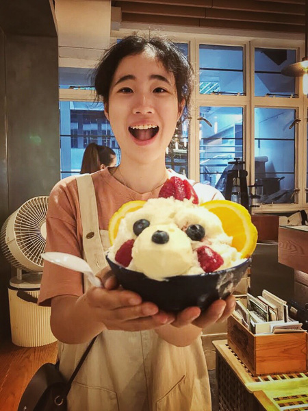 Photo of Angel holding an ice cream sundae and laughing