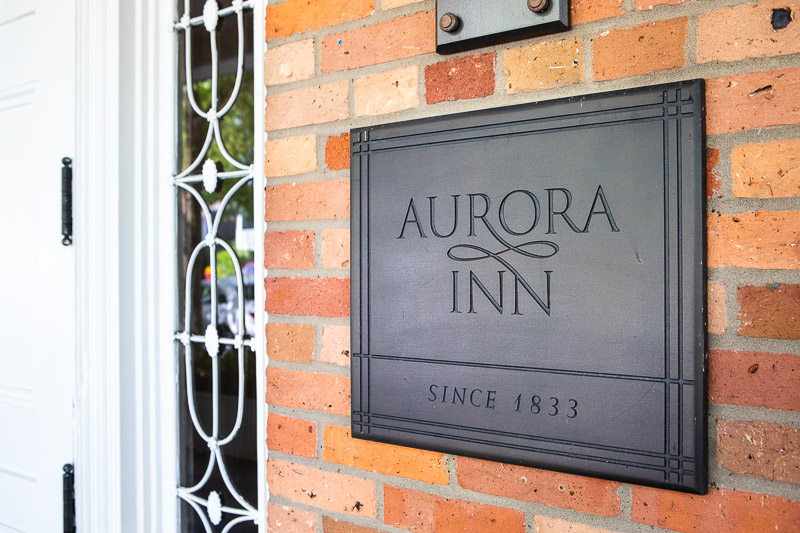 Photo of the sign by the front door that says Aurora Inn