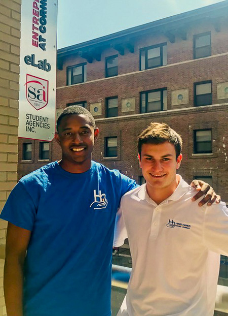 Photo of CJ and Lucas in front of the Student Agencies building