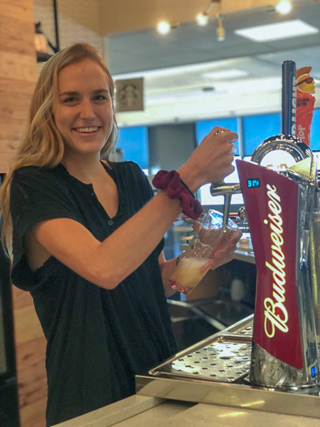 Photo of Katie filling a beer glass at a Budweiser tap