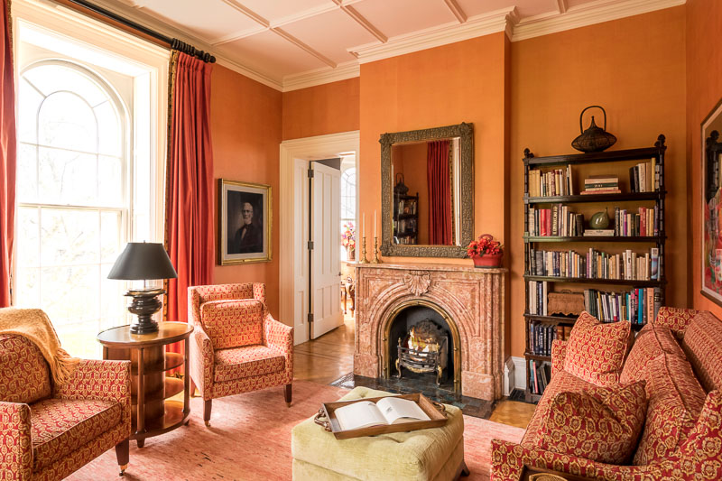 Photo of a cozy room with bookshelves, a fireplace, and soft chairs