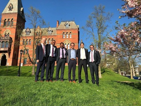 Photo of 6 men standing in the grass outside of Sage Hall