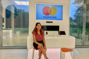 Photo of Sonal in front of a Mastercard digital display
